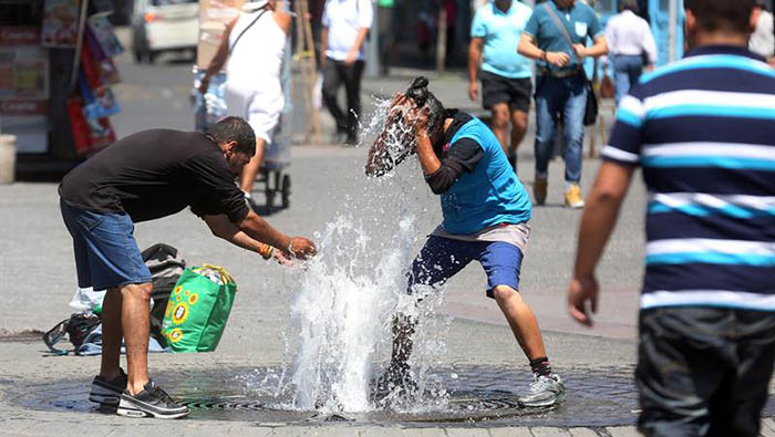 Dos personas se refrescan en las calles de Santiago (Chile) debido a las altas temperaturas registradas en ese país la semana pasada.